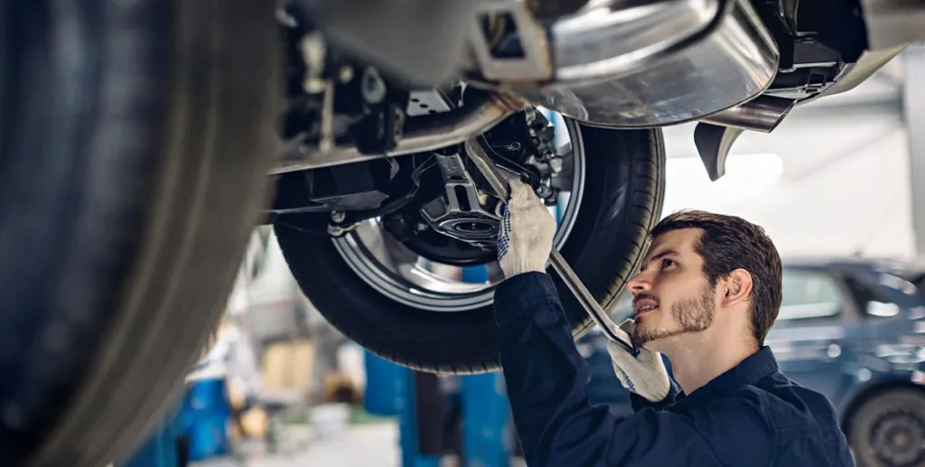 How to open a mechanic shop: car mechanic fixing a tyre wheel