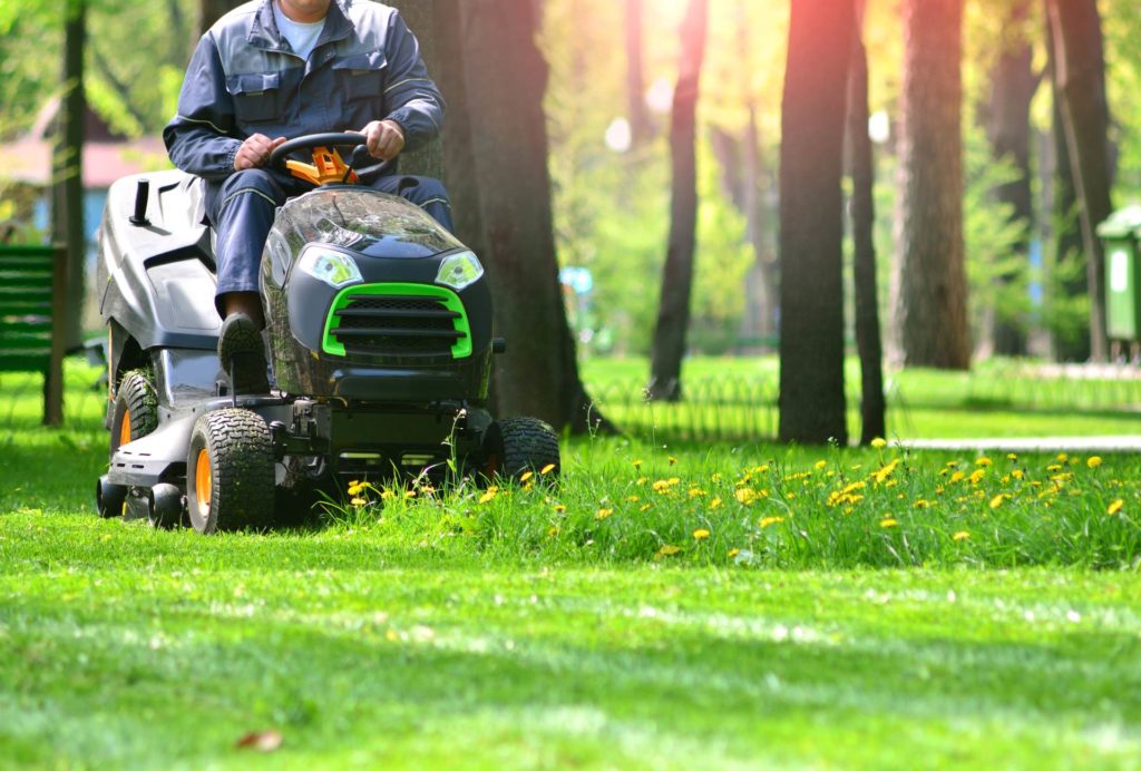 How to get lawn care customers fast: Man seated on lawn mower