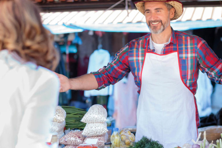 How to promote your business locally: farmer welcoming a customer