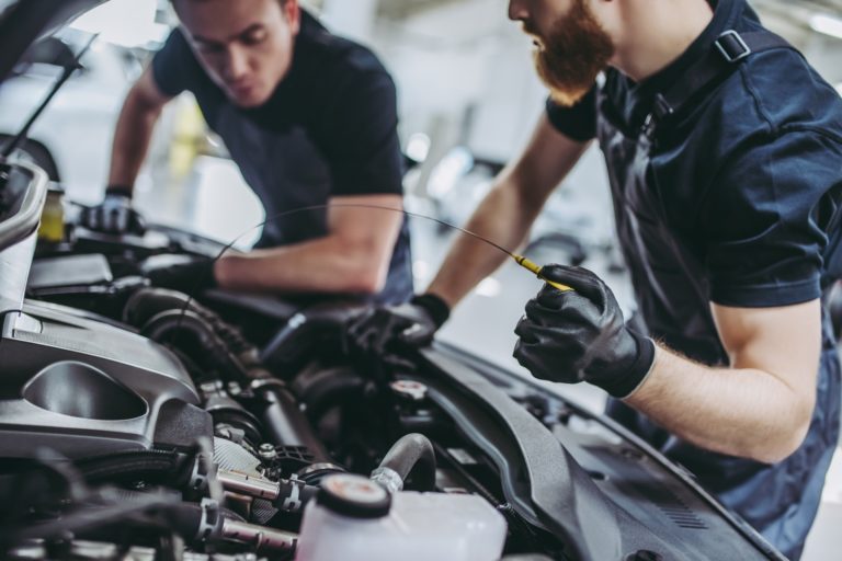 Auto repair marketing: Two mechanics working on a car engine