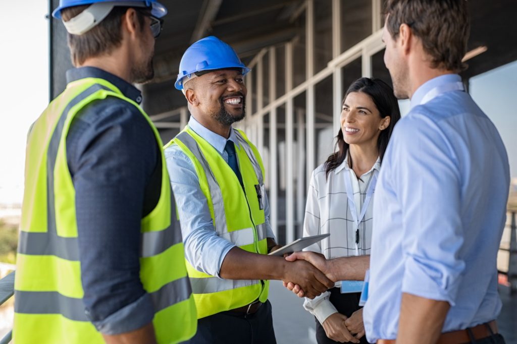 Construction marketing ideas: Engineer and client shaking hands at a construction site