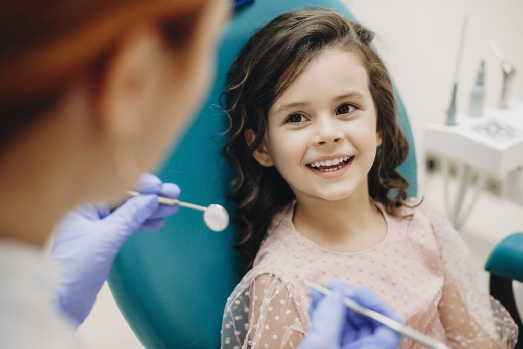 Little kid smiling at a pediatric dentist 