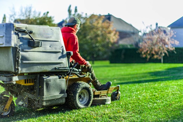 How to start a lawn care business: Man on electric lawn mower