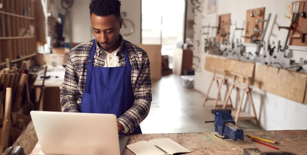 How to write a business description: Man in apron working at laptop