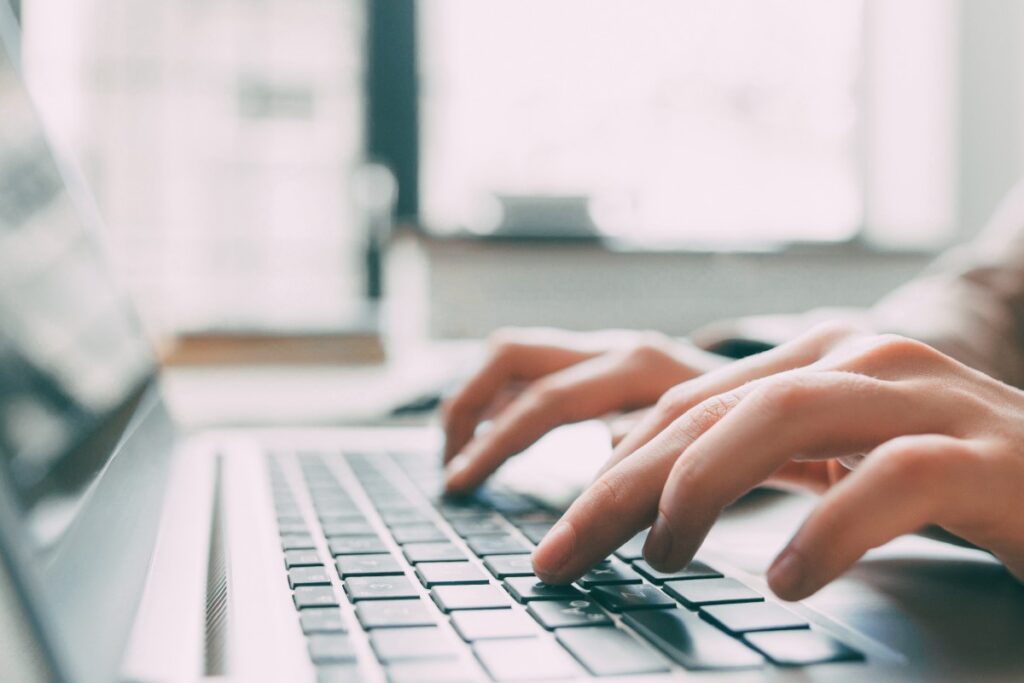 Closeup of person's hands typing on laptop