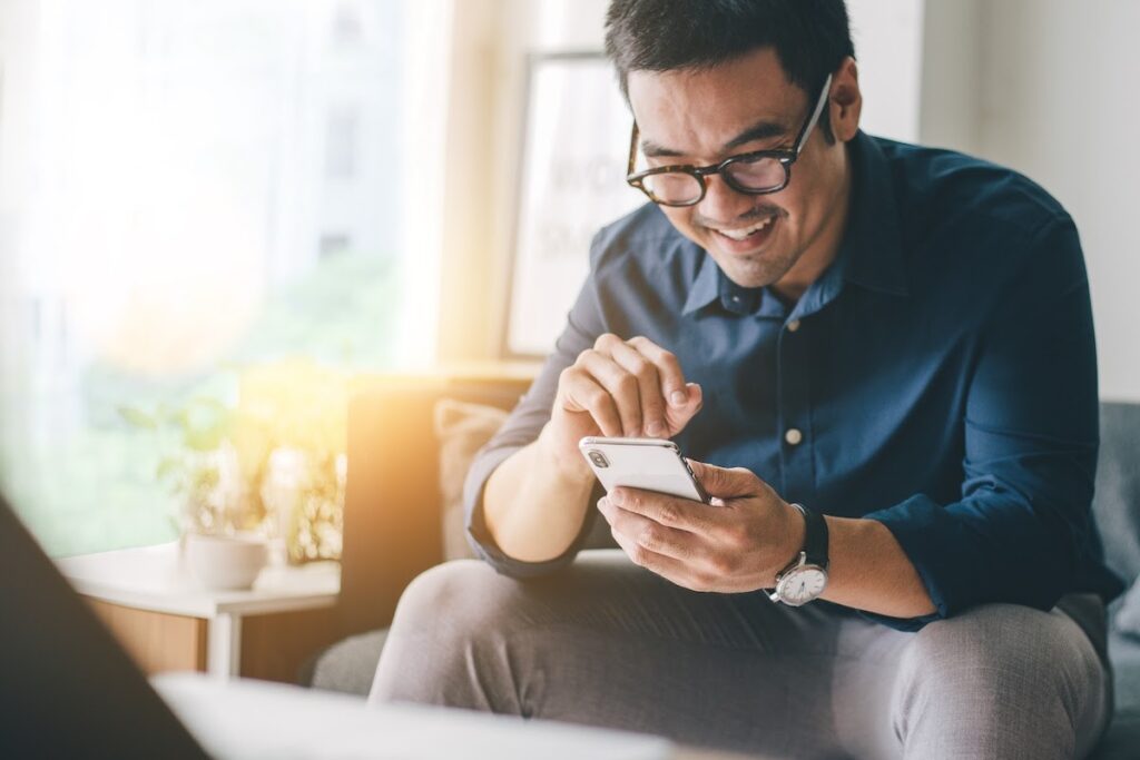 Smiling man looking at his cell phone