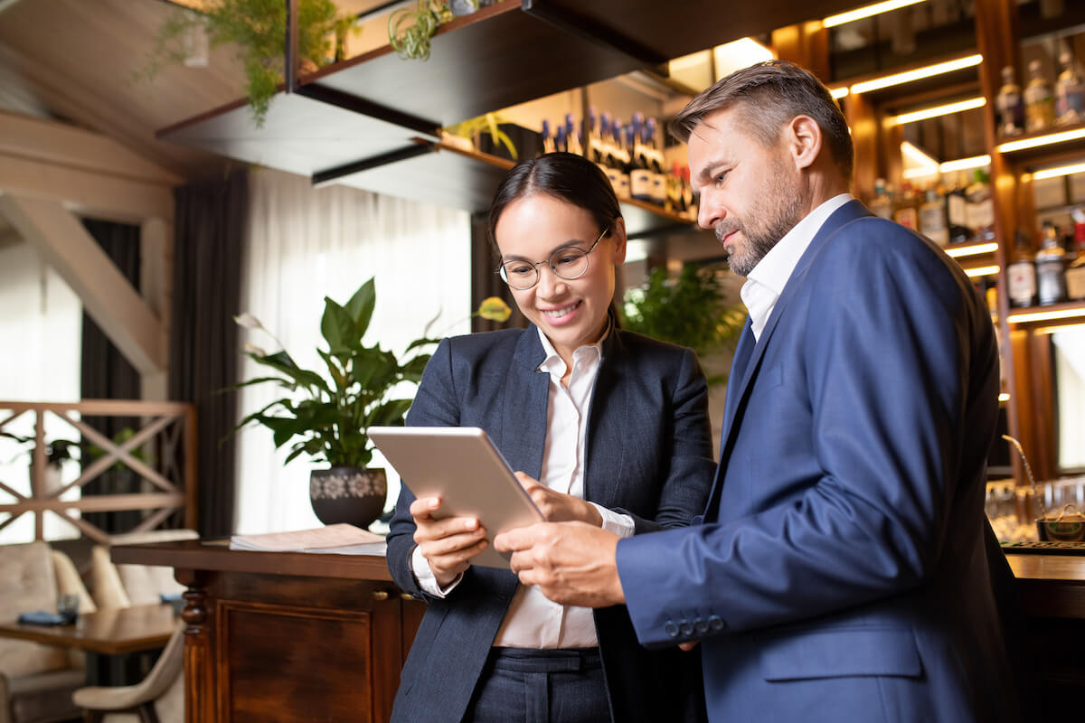 Restaurant manager: business-partners checking a tablet