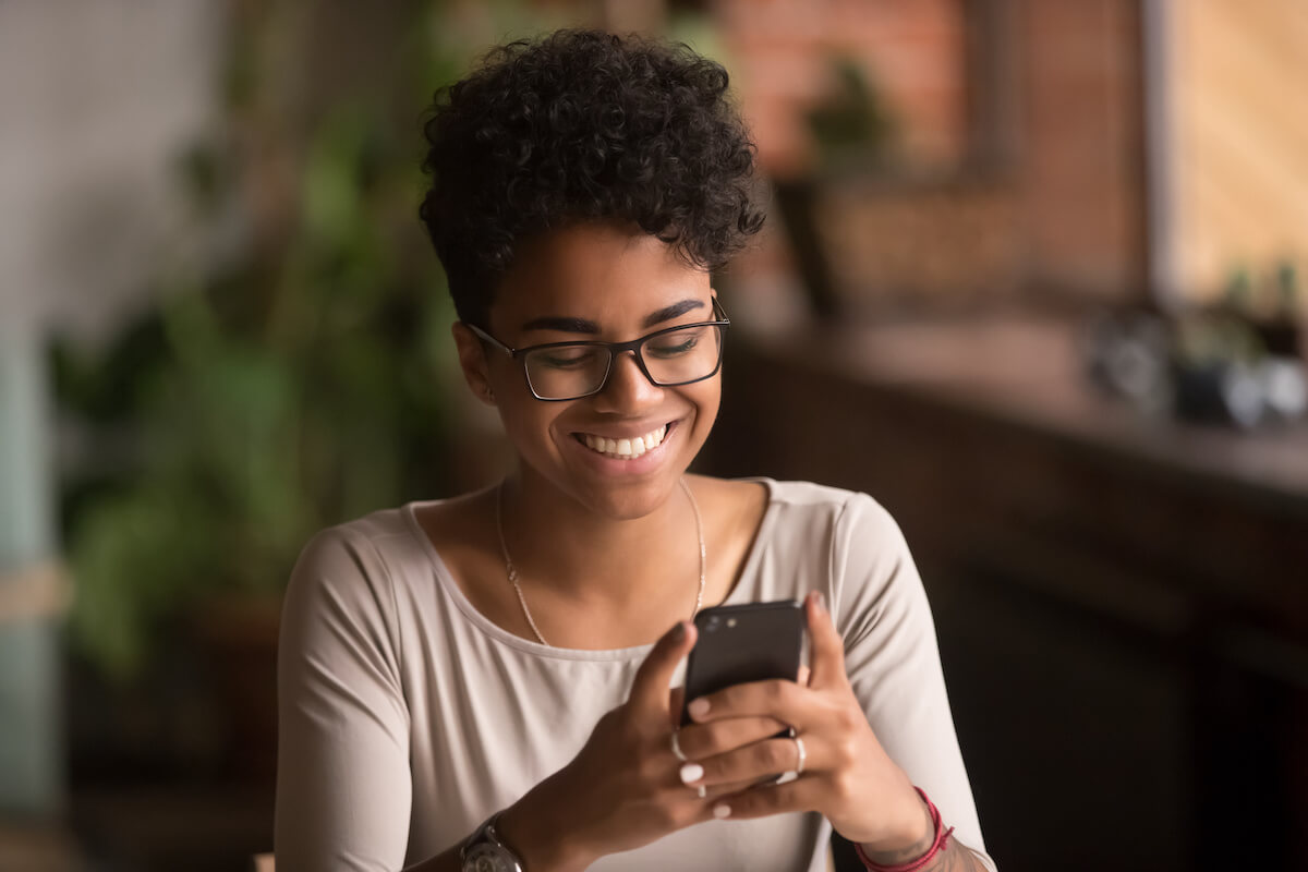 Smiling woman ordering food online via her phone