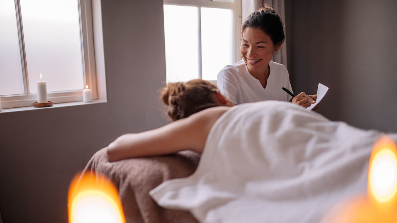 Massage therapy business plan: masseuse taking notes from a customer