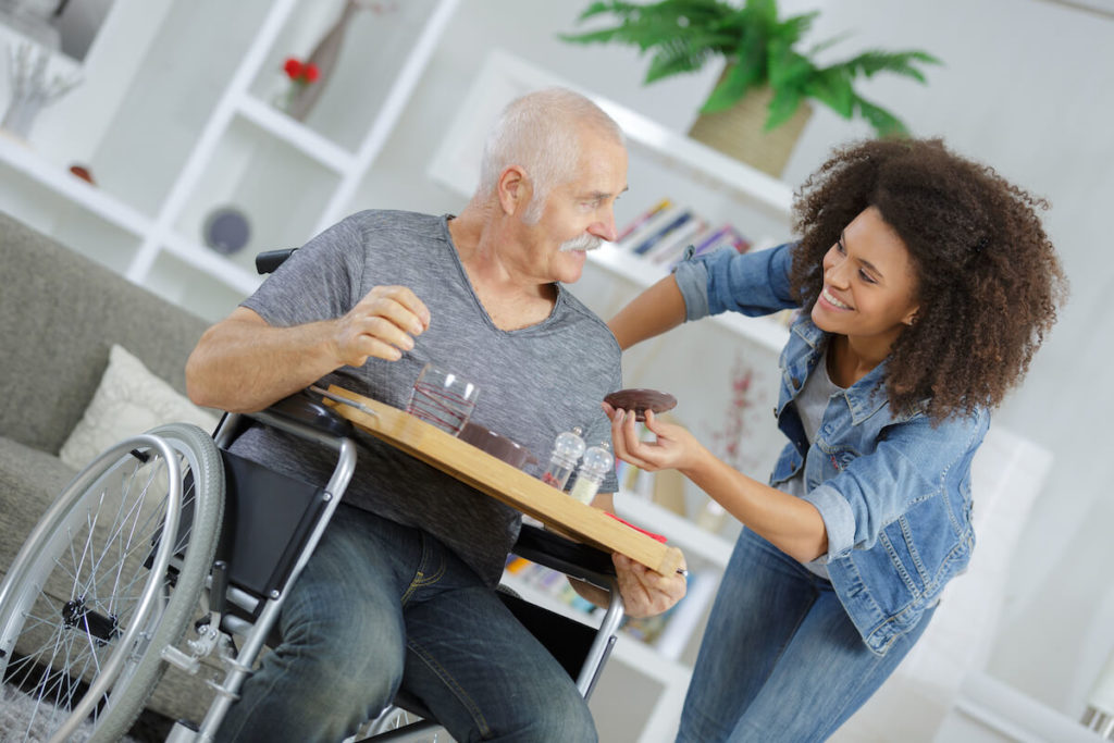 Caregiver giving food to a senior man