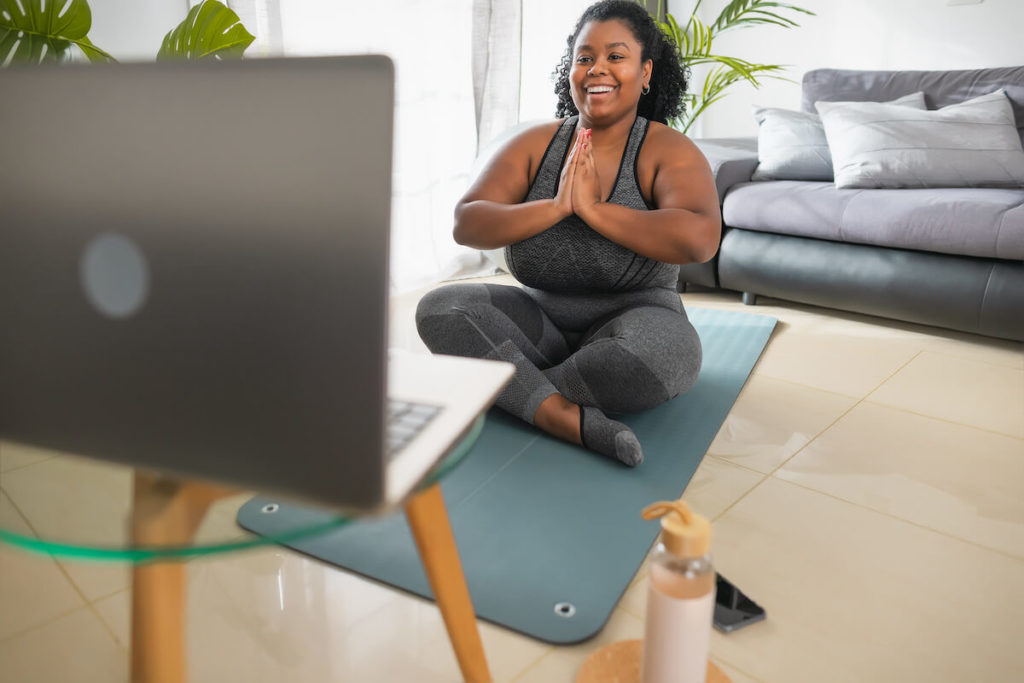 Woman happily practicing yoga at home