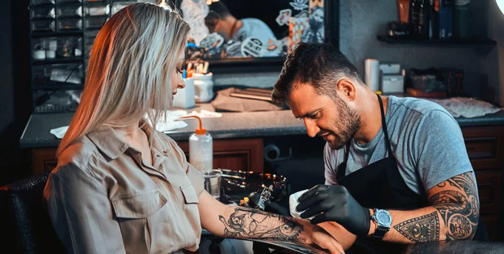 Opening tattoo shop: young woman getting a tattoo 