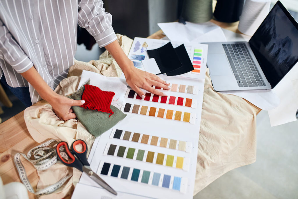 How to start a clothing line: designer looking at different color swatches