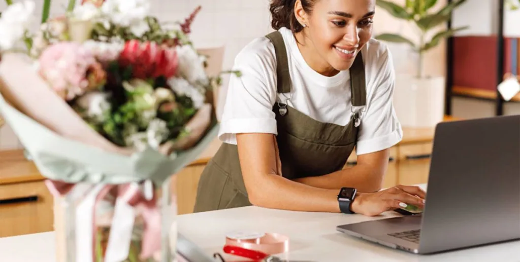 Self-service advertising for small businesses: florist using laptop to research advertising ideas 