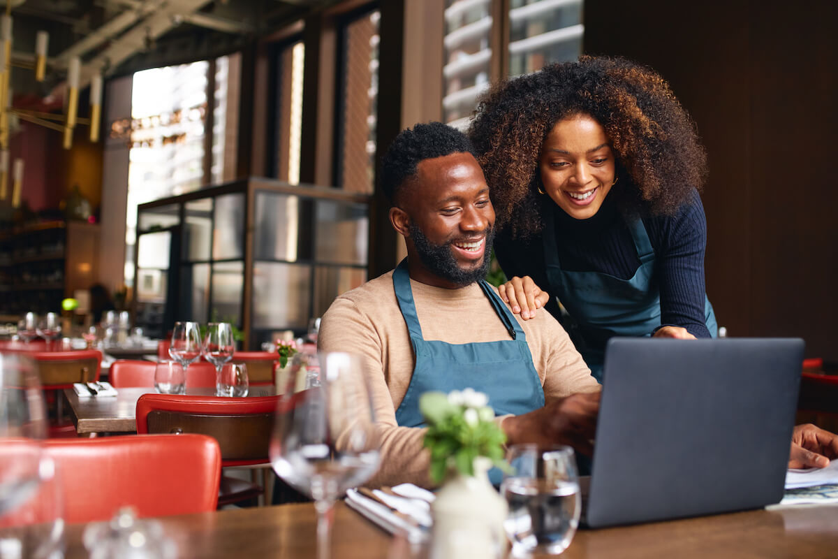 Restaurant owners using a laptop