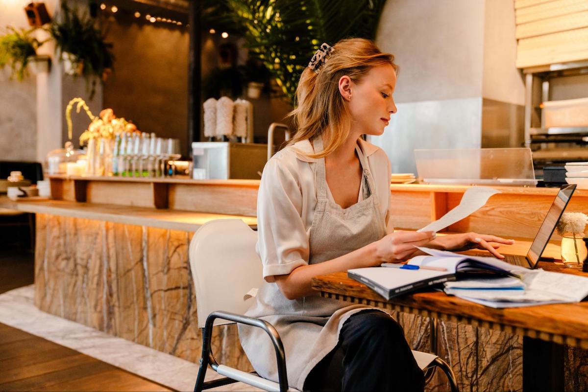 Manager using a laptop while holding a document