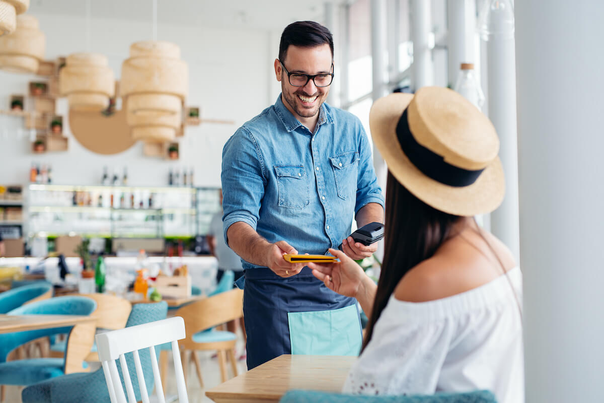 Waiter happily getting the bill from a customer