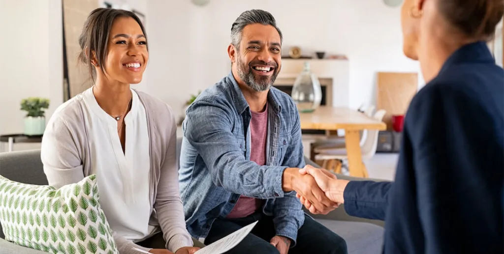 Free insurance leads: couple shaking hands with an agent