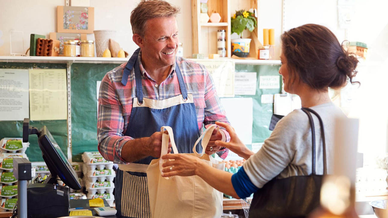 Customer acquisition strategies: grocery store owner serving customer
