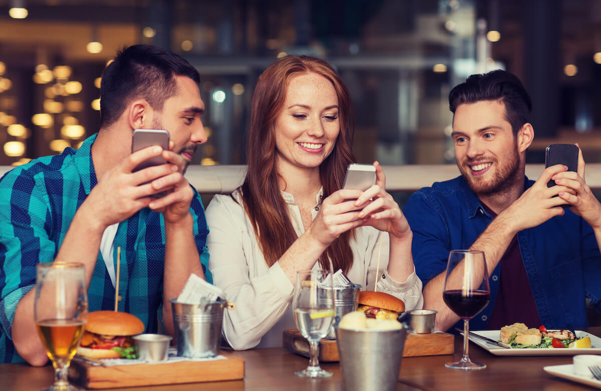 New Year, New FOH: group of friends using their phones at a restaurant
