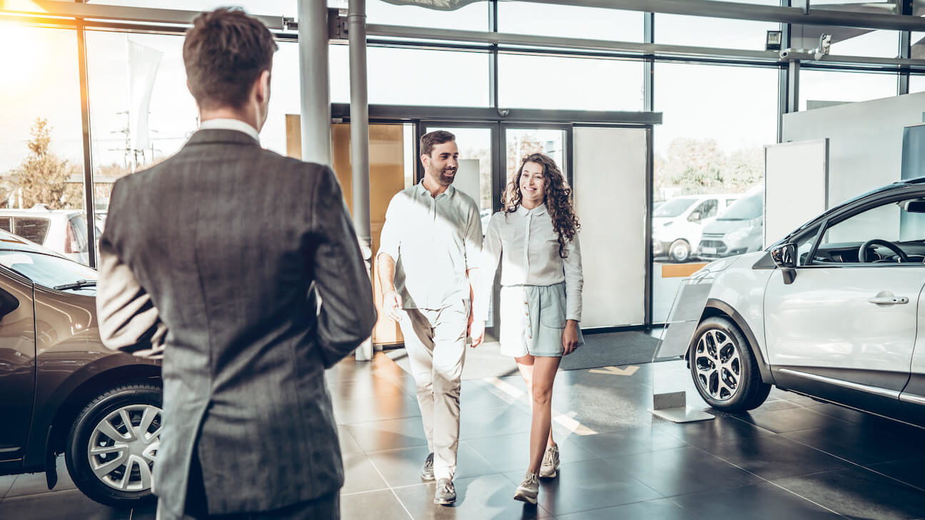 Auto leads: couple walking towards a salesperson