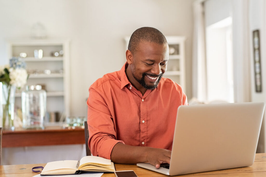 Sales follow up email: entrepreneur happily using a laptop