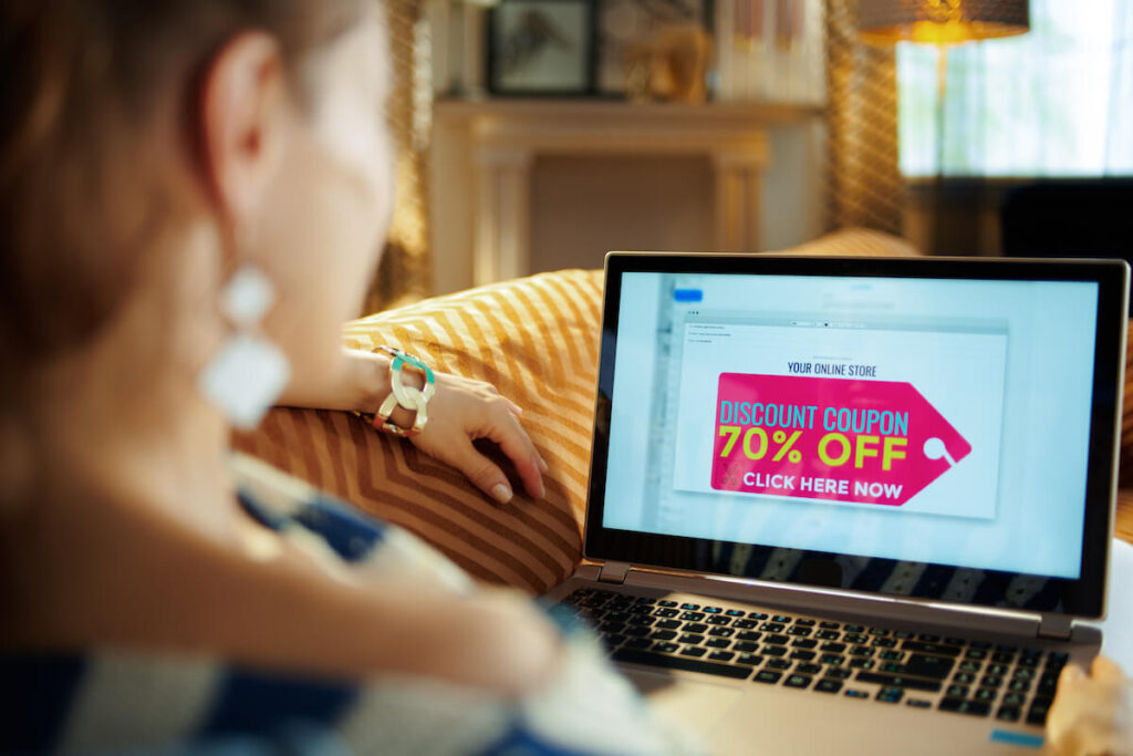 Woman using a laptop with a discount coupon on the screen