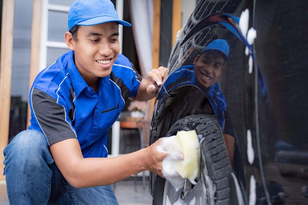 Car wash owner cleaning a tyre