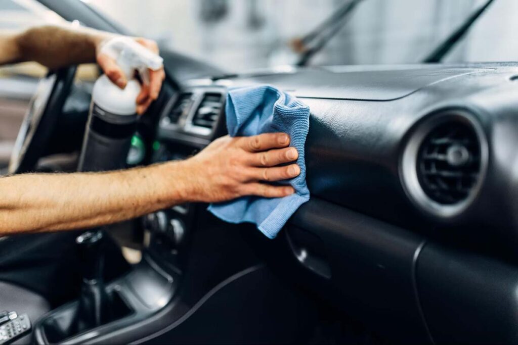 Car wash attendant cleaning the inside of a car