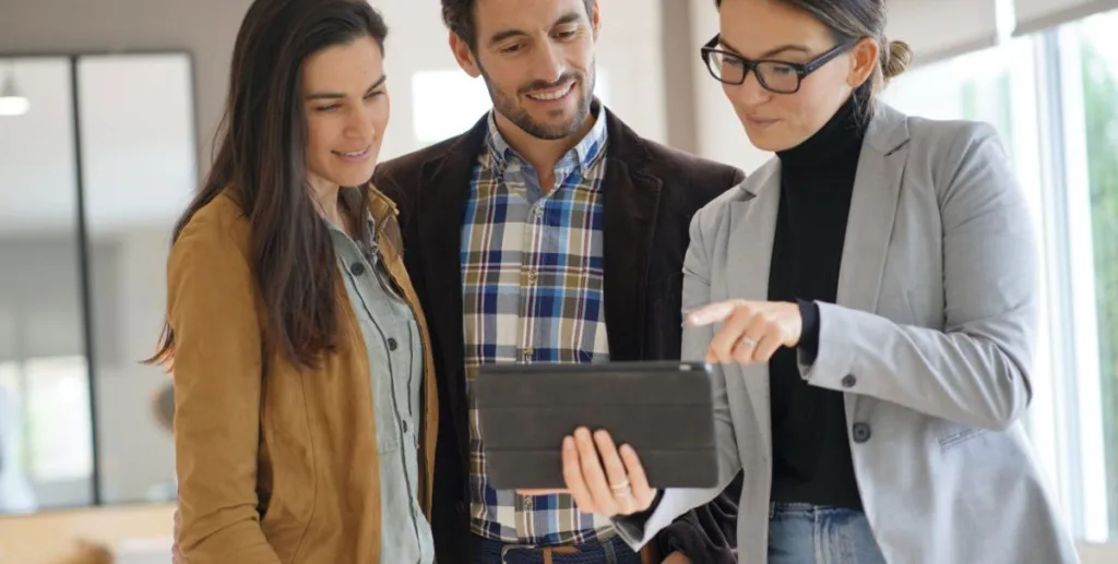 How to get real estate leads: real estate agent showing a couple around a house