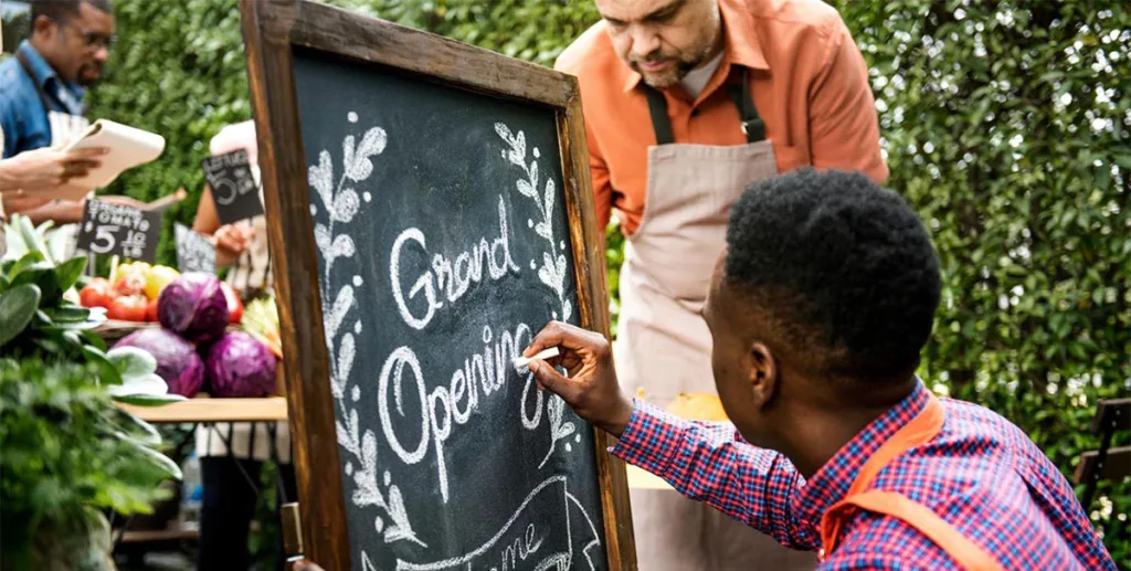 Best marketing for new business: biz owner updating retail signage outside store