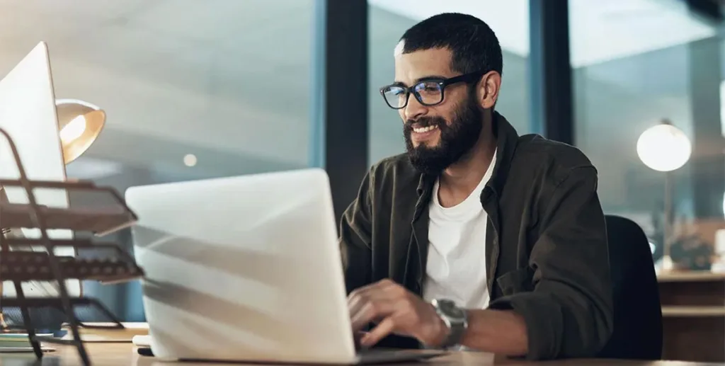 Online advertising examples: advertising executive sitting at desk using his laptop