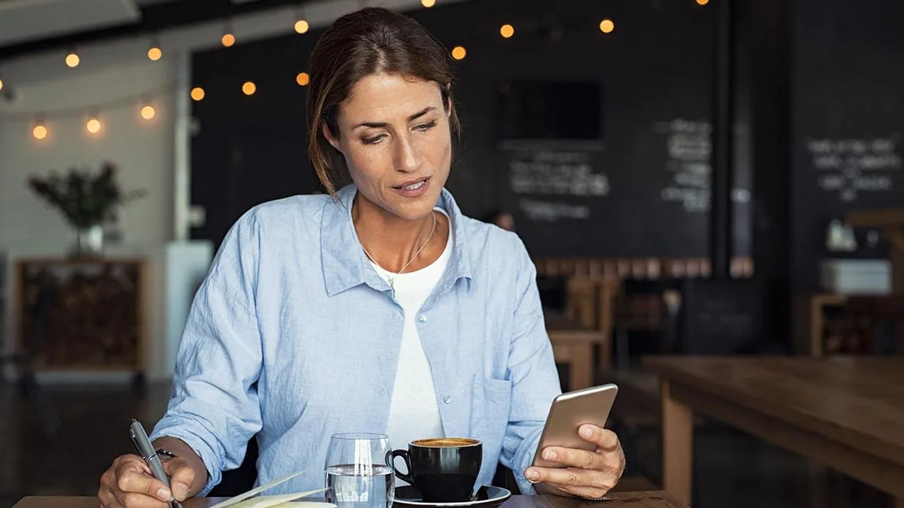Advantages of online advertising: business owner in cafe using phone