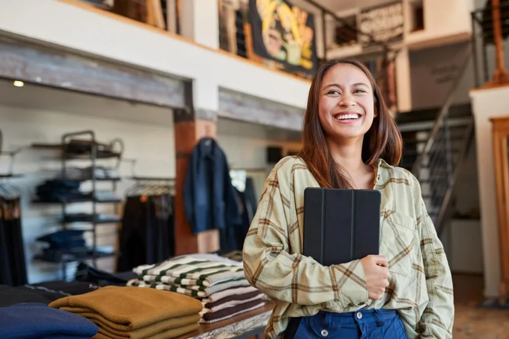 Small business owner holding an iPad in her store