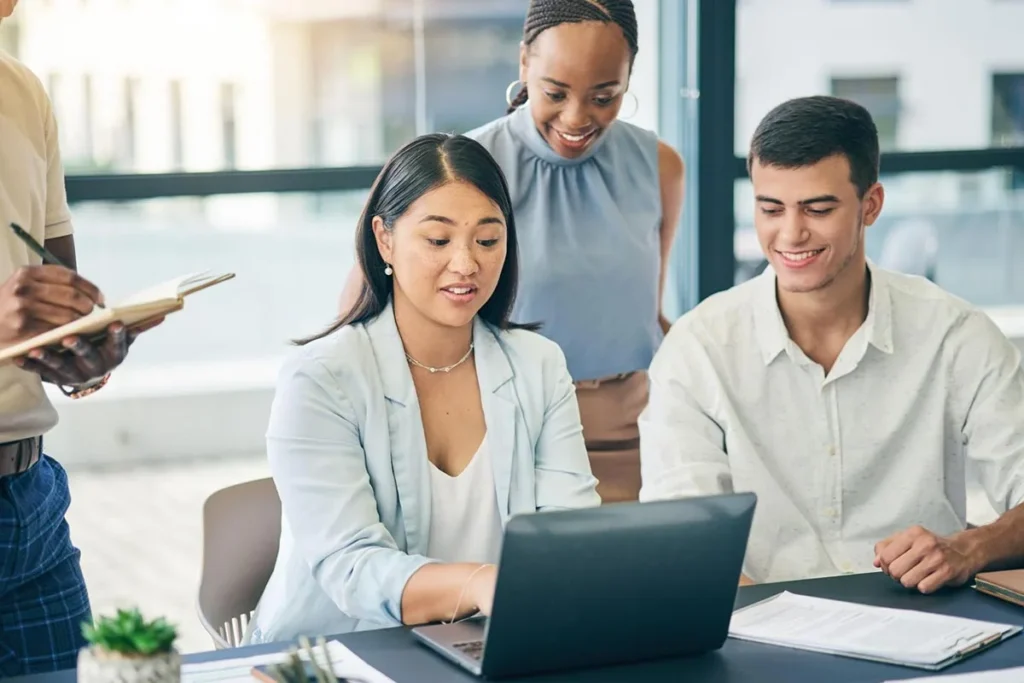 Marketing team collaborating on a laptop during a productive meeting