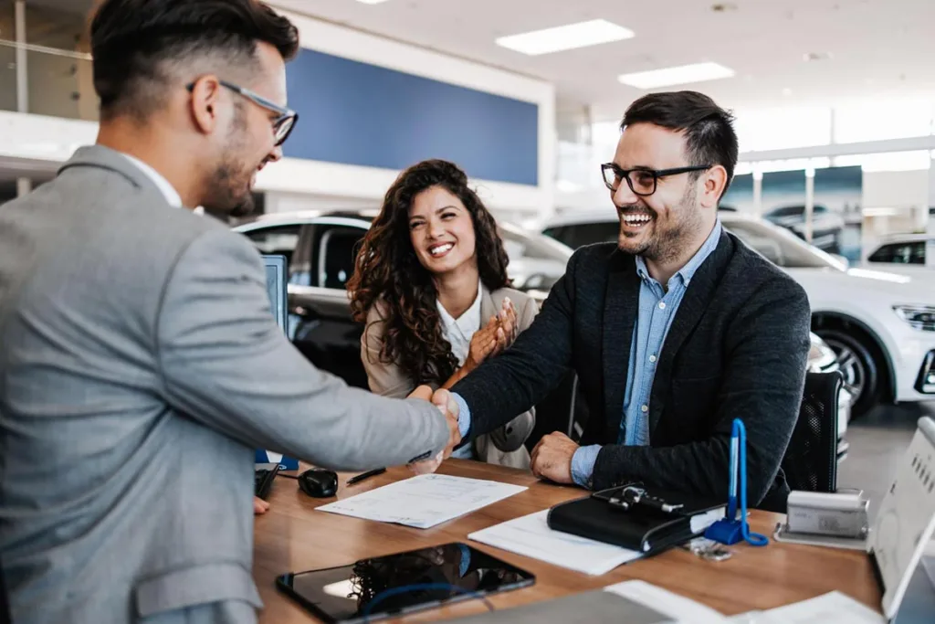 Prospecting leads: young couple in car showroom buying a new car