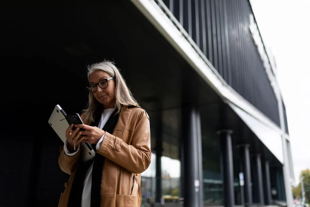 Woman standing outside a building using her phone
