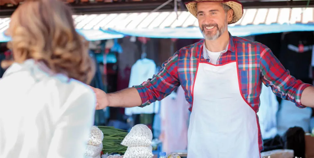 How to promote your business locally: farmer welcoming a customer