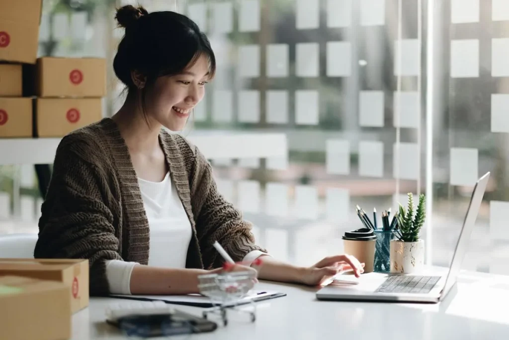 A young business owner creating an online ad using a laptop