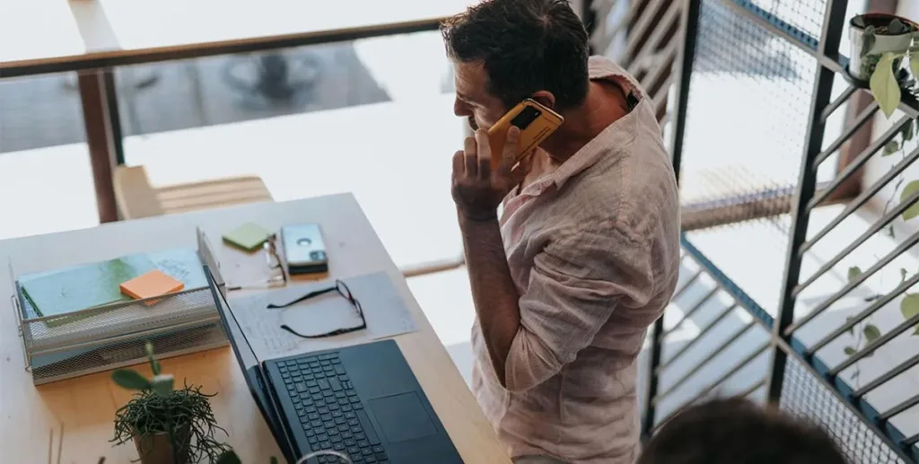 Small business owner using laptop while talking on phone