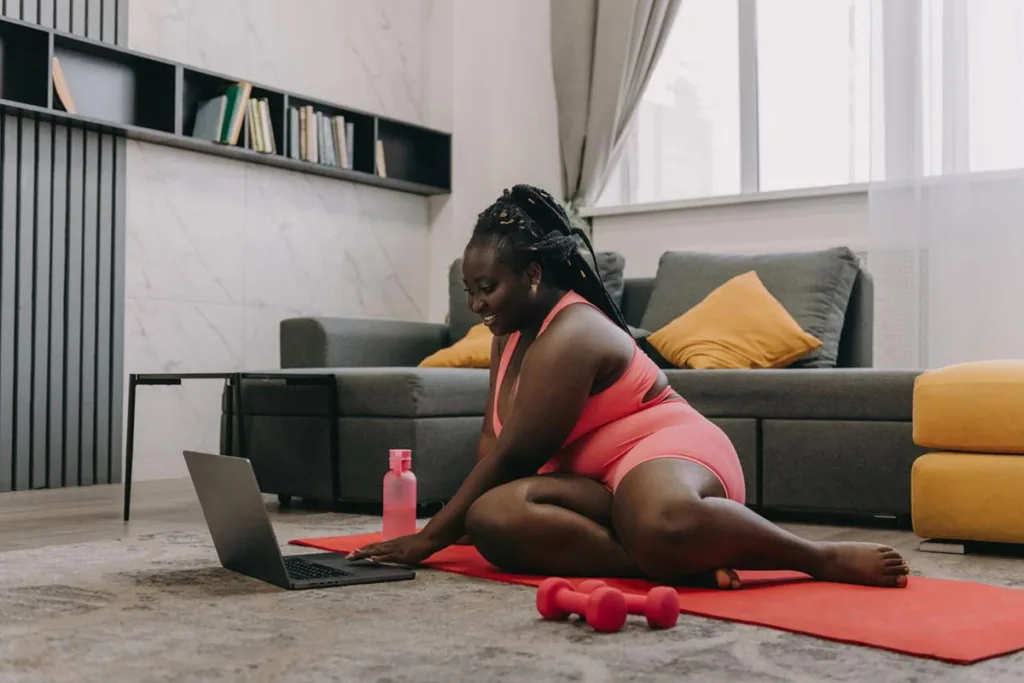 Woman doing an online yoga class at home in front of her laptop