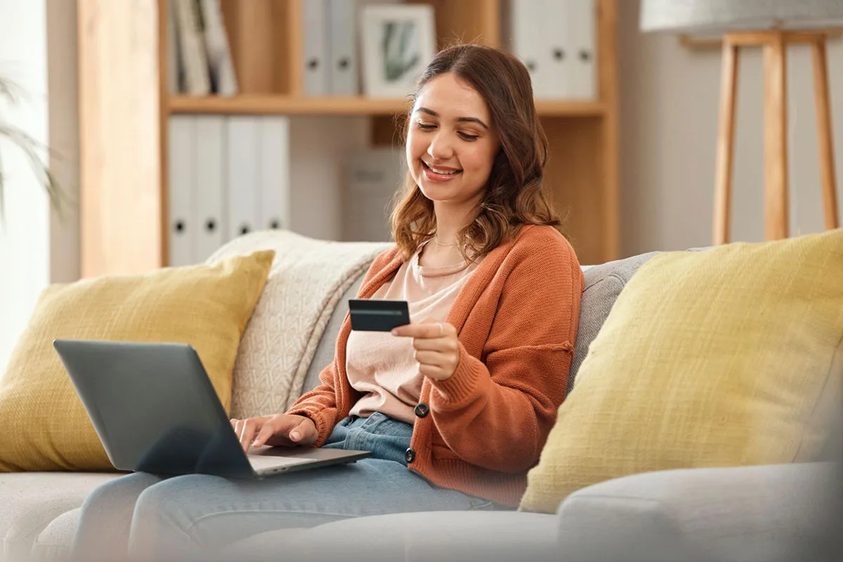 A young woman shopping online at home using a laptop