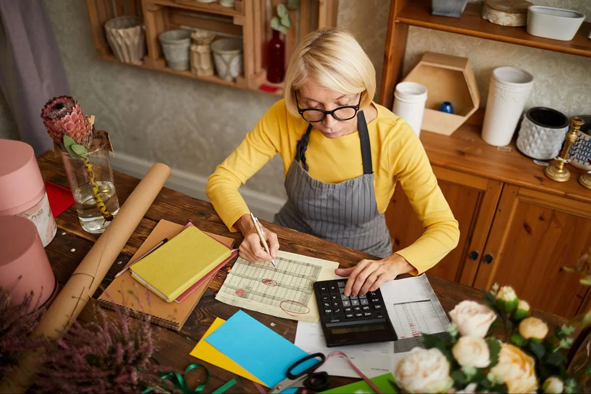 Florist sitting down at desk doing bookkeeping