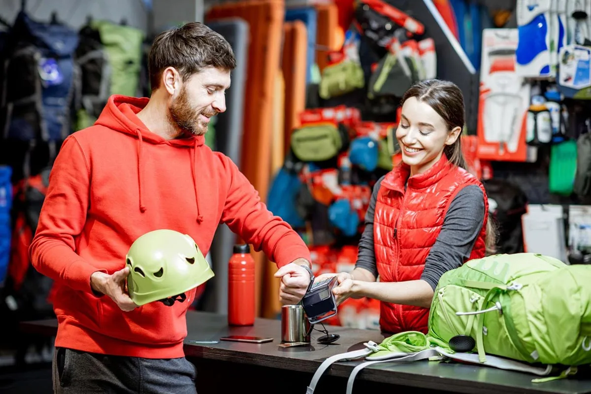 Customer purchasing a safety helmet at a shop using a smartwatch to make payment