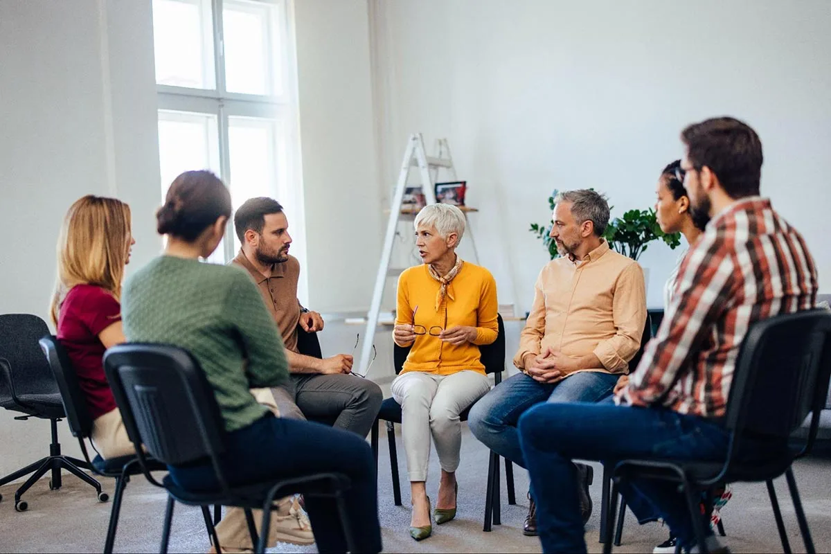 Group of people sitting around talking to each other