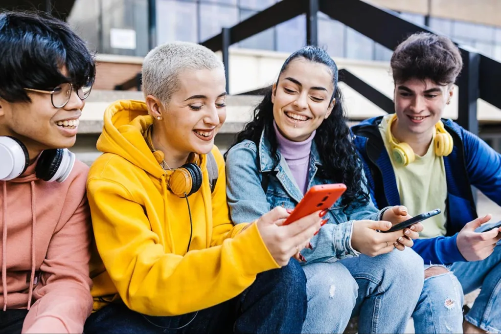 Group of friends using smartphones outdoors