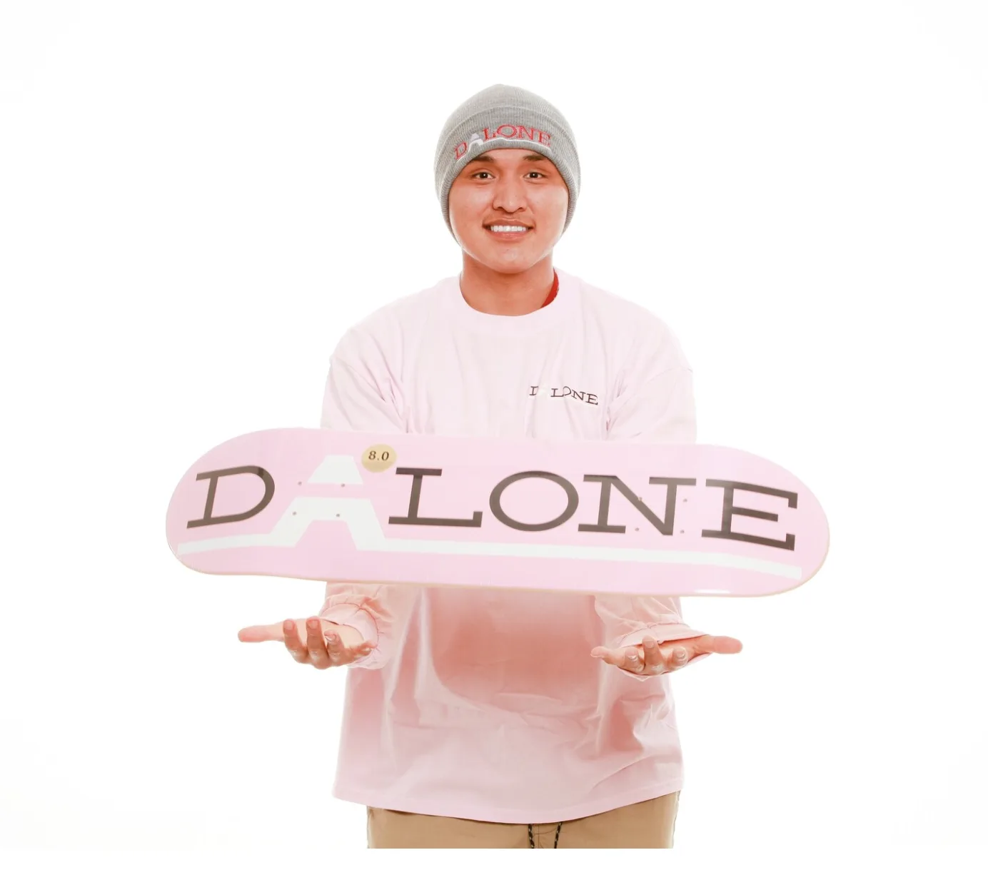 Jerome holding a skateboard that showcases the enlarged ‘A’ in the middle of the word, representing the experience of skateboarding and being alone