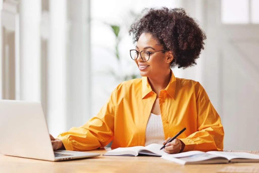 SEO manager working at a desk with a laptop and notepad