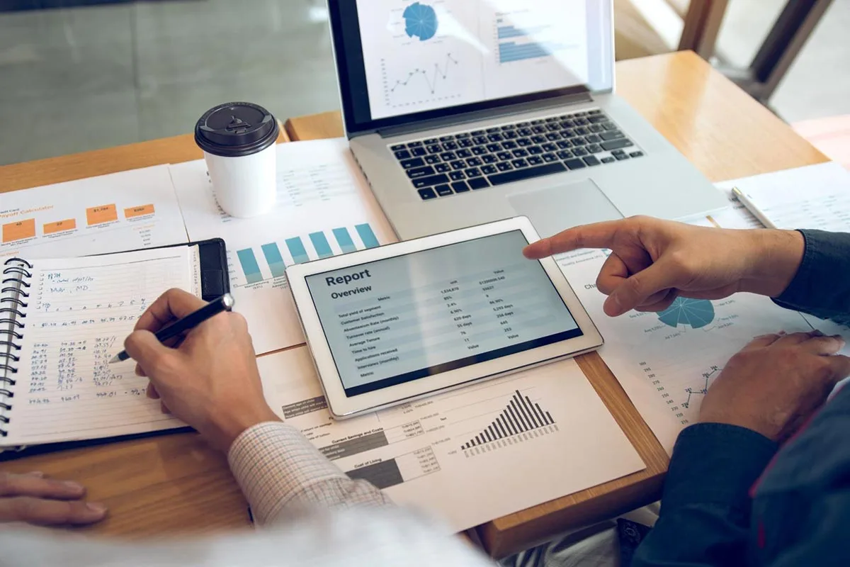 Two marketing managers sitting at a table reviewing strategy reports