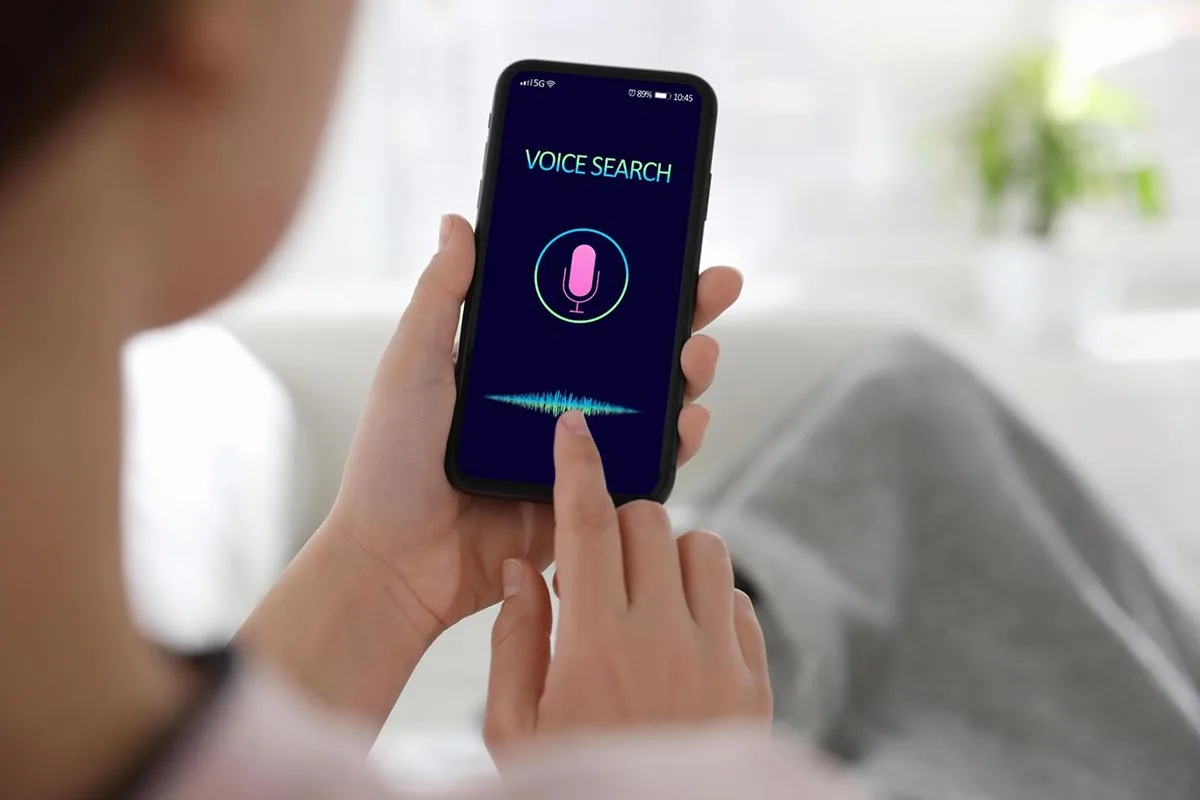 Woman using voice search on smartphone to showcase advancements in tech and user preferences